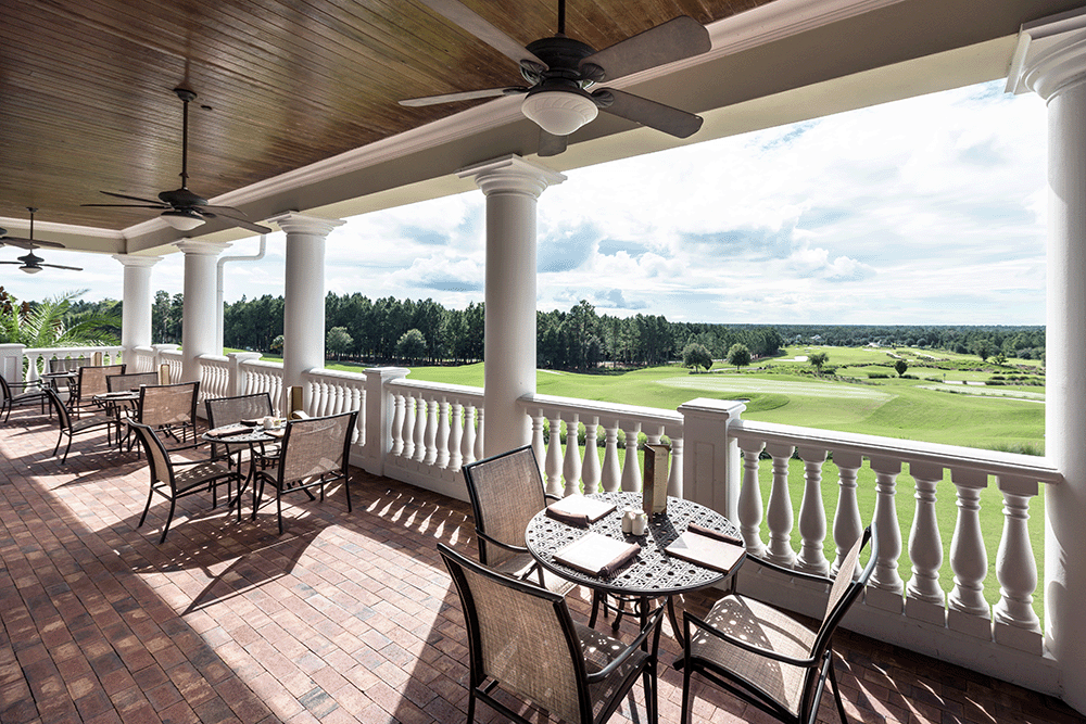 Outdoor seating at a clubhouse overlooking the golf course